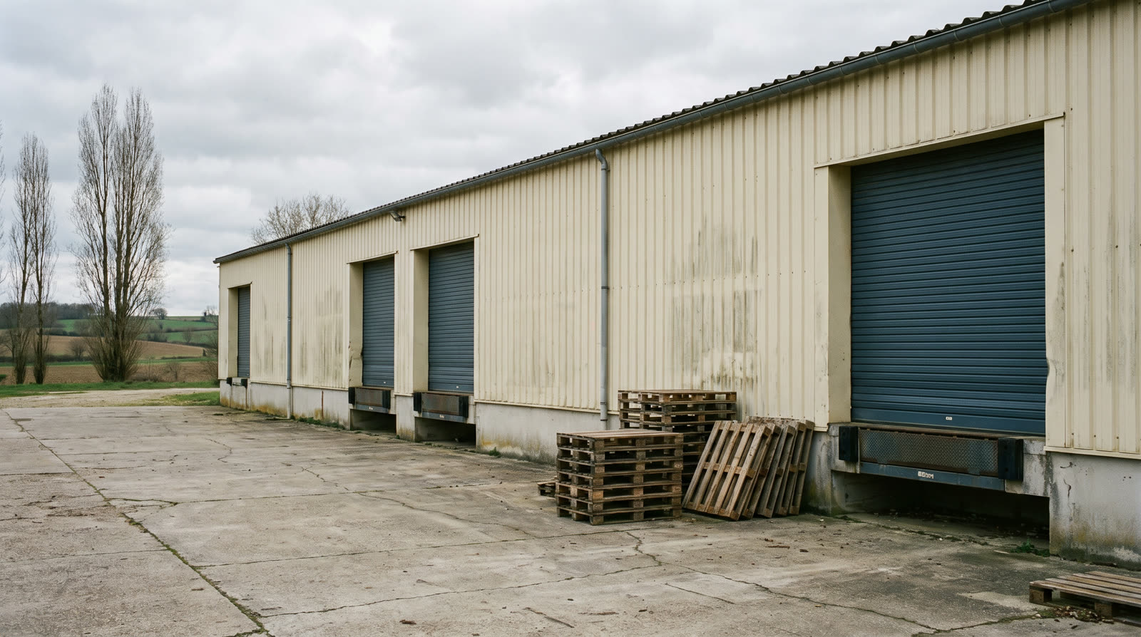 Entrepôt logistique en Lorraine : façade bardée, quais de chargement et aire de manœuvre en béton — les surfaces dont la pondération est la plus souvent contestable.