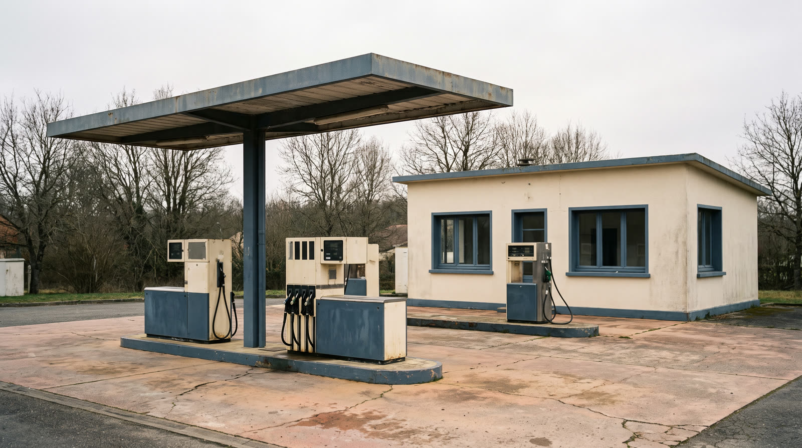Station-service de bord de route : îlots de distribution sous auvent et boutique — un ensemble où auvent, dalle et bâtiment relèvent de pondérations différentes.